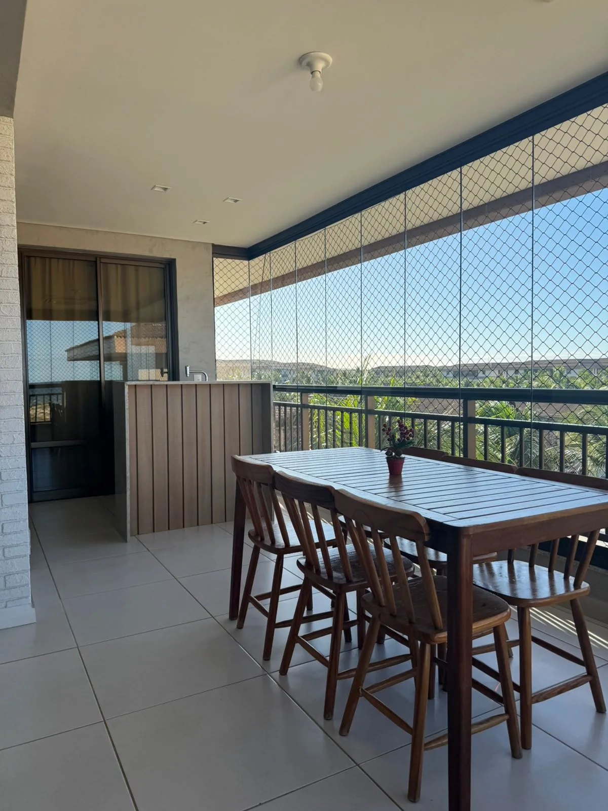 Varanda gourmet com cortina de vidro do apartamento Mandara Lanai